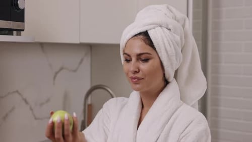 Smiling Woman in Robe with Green Apple