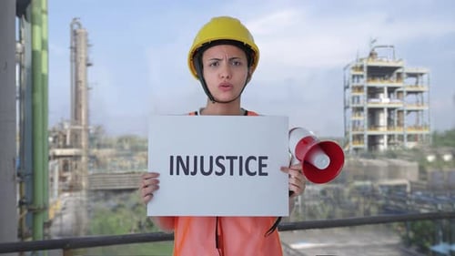 Woman Protesting Injustice with Megaphone at Industrial Site