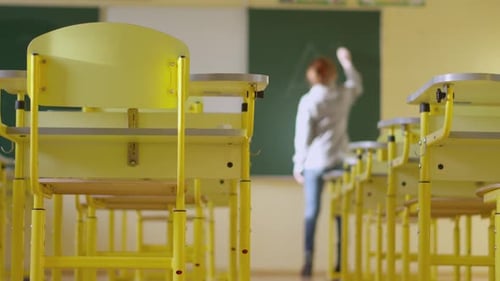 A Girl Student Writes on a Green Board