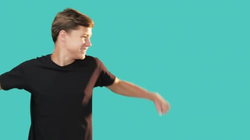 Enthusiastic Man Nods, Thumbs Up on Teal Background