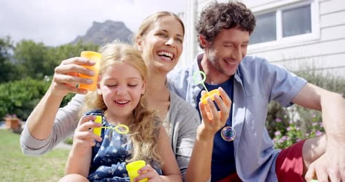 Family, love and girl with bubbles in the garden enjoying vacation, holiday and weekend at home