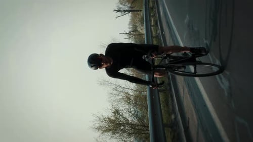 Professional cyclist riding bicycle during cycling training. Vertical video