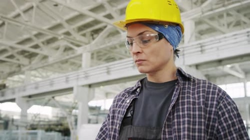Female Engineer Using Machine at Industrial Plant
