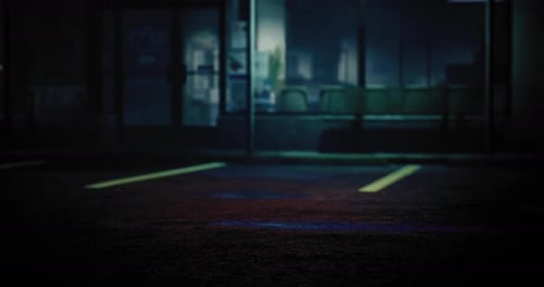 Nighttime View of an Empty Parking Lot with Faint Light From Nearby Buildings