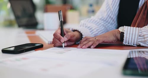 Adult Analyzing Data With Pen at Desk