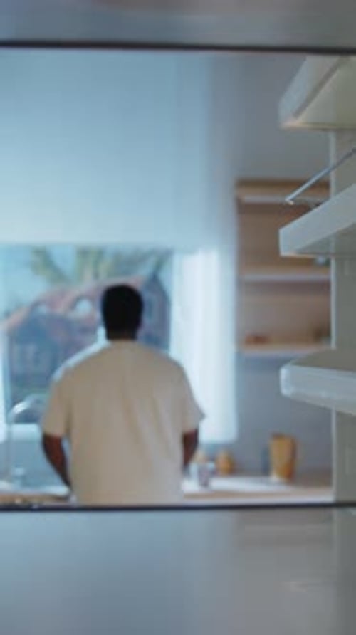 Teen boy takes cake from inside refrigerator