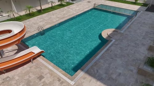 Aerial View Pool With a Fun Water Slide Families Enjoying a Sunny Day