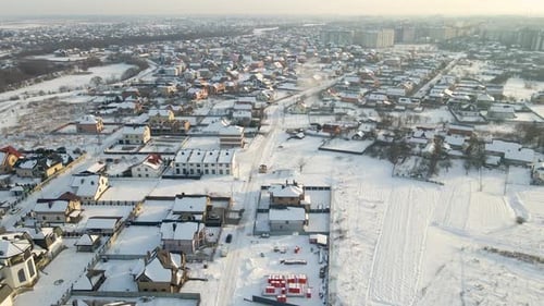 Aerial View of Residential Houses with Snow Covered Roofops in Suburban Rural Town Area in Winter