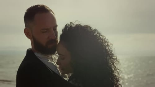 People Cuddling Outdoors At Ocean Beach. Relaxing Married Couple Standing Together At Sea Shore C...