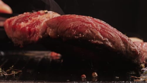 Fresh Marbled Beef with Pepper Salt and Rosemary Closeup Macro Cooking Juicy Steak on Grill with Oil