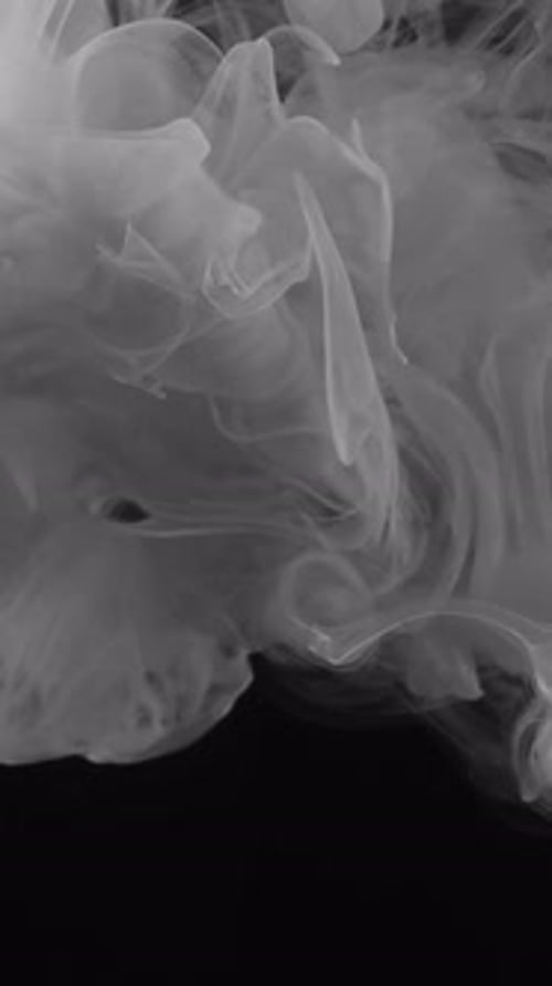 Grey Ink Swirls Against Black Background