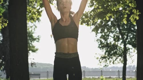 Young Woman in Sportswear Exercising in Park on Sunny Day