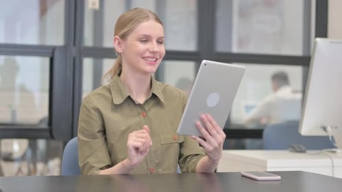 Young Businesswoman Doing Video Chat on Tablet in Office
