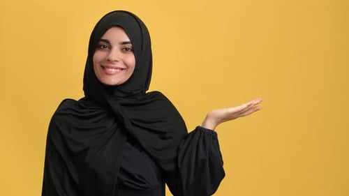 Portrait Smiling Beautiful Muslim Woman in Black Hijab Pointing Copy Space Posing Isolated