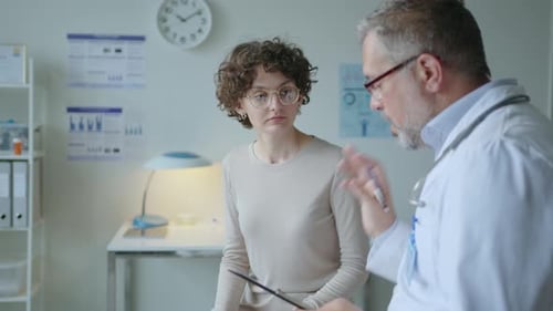 Young Woman Discussing Health with Doctor in Office