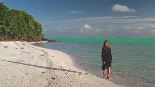 Young Woman Walking on a White Sand Beach in a Tropical Paradise
