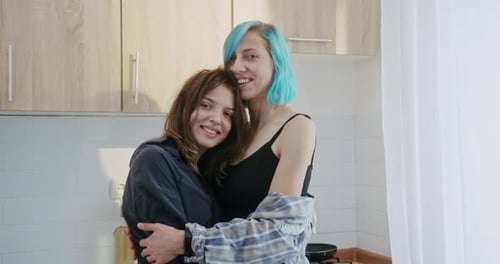 Loving Women Embrace Tenderly in Kitchen Together