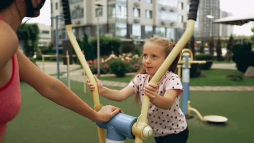 Young Girl Enjoys Outdoor Exercise with a Fitness Machine in a City Park During the Afternoon