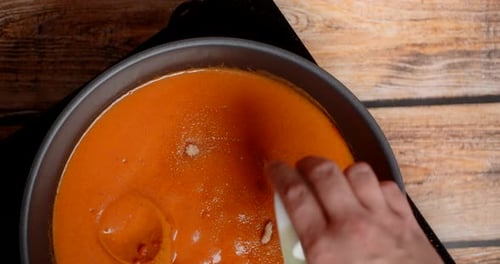Cream and Powder Added to Bright Orange Sauce