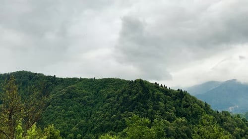 Lush green mountains under cloudy sky in daytime