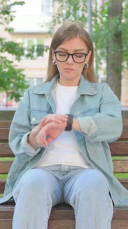Vertical Video, Waiting Casual Woman Checking Wrist Watch on Park Bench