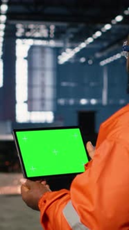 Vertical Video Green Screen Tablet with Worker Managing Operation Tasks Across Factory Floor