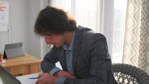 Adult Male Reads Documents in Brightly Lit Room