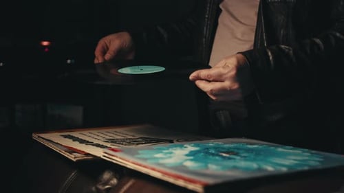 man looking at records in a 70s setting and wardrobe