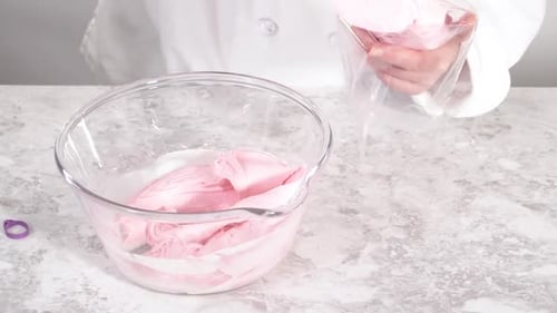 Scooping Pink Vanilla Buttercream Frosting Into a Piping Bag