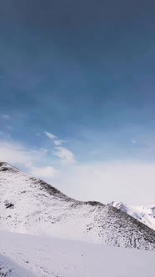 Vertical video of Aerial view drone flying over beautiful white snowy mountains
