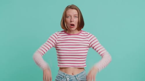 Blonde Woman Makes Silly Faces Against Teal Backdrop
