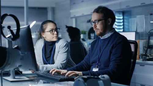 Multiethnisches Team junger weiblicher und männlicher Forscher, die an ihrem Arbeitsplatzcomputer tippen