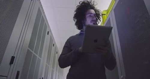 Man Using Tablet in Dimly Lit Data Center