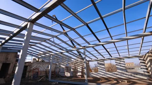 On the top of the building under construction with a frame for future roof.