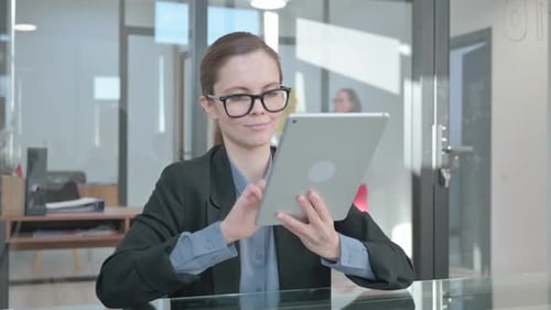 Woman Works on Tablet in Modern Office