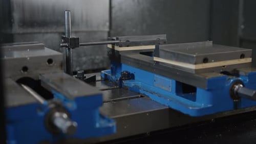 Close-up of industrial equipment in operation with metal parts and blue