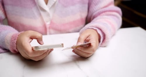 Close-up woman's hand holds a smartphone and use a mockup Bank credit card for online shopping servi