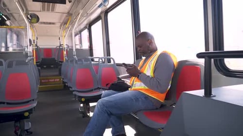 Man on bus looking at cell phone