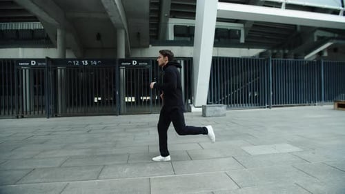 Sportsman Running On Urban Street In Slow Motion. Male Runner Jogging On Outdoor Workout. Handsom...