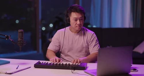 Young Adult Creates Music at Home at Night