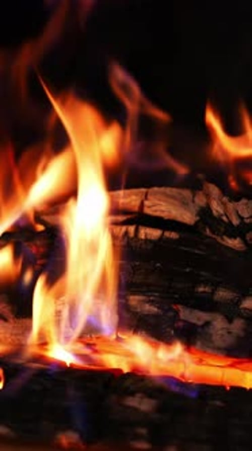 Bright flame of burning fireplace. Close up shot of warm cozy burning fire in a brick fireplace.