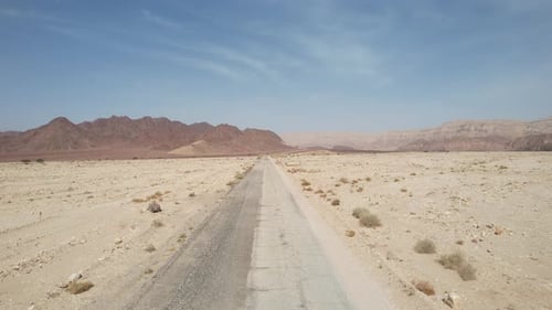 Aerial drone view low over a dry road in the Timna desert, sunny day in Israel