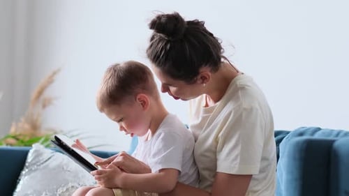 Mother and Child Using Tablet Together on Couch