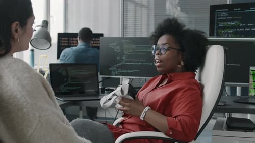 Diverse Engineers Discussing Experience with VR Headset in Office