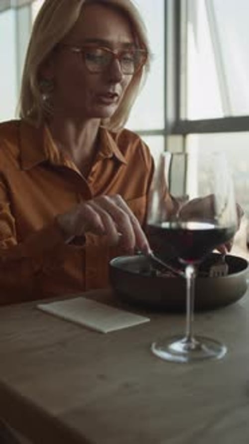 Vertical of Female Guest Talking during Lunch in Restaurant
