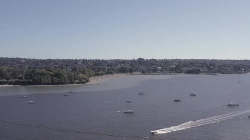 Aerial fly over from English Bay to Kitsilano Beach on a hot summer day as boaters relax suntan lies