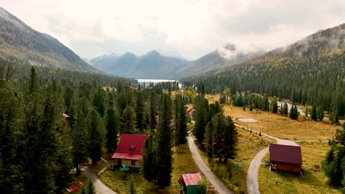 Bergtaldorf mit See und dichtem Nadelwald