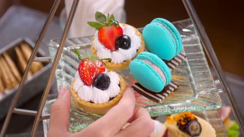 Woman Hand Take a Dessert Tart From Sweet Traditional Afternoon Tea Stand