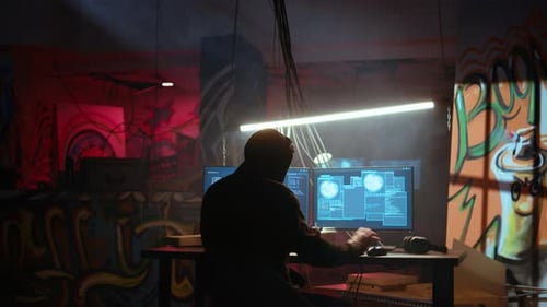 Hacker em local escondido com paredes de grafite usando PC para implantar malware