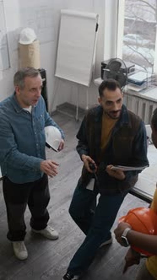 Equipo de ingenieros varones discutiendo en la oficina de construcción